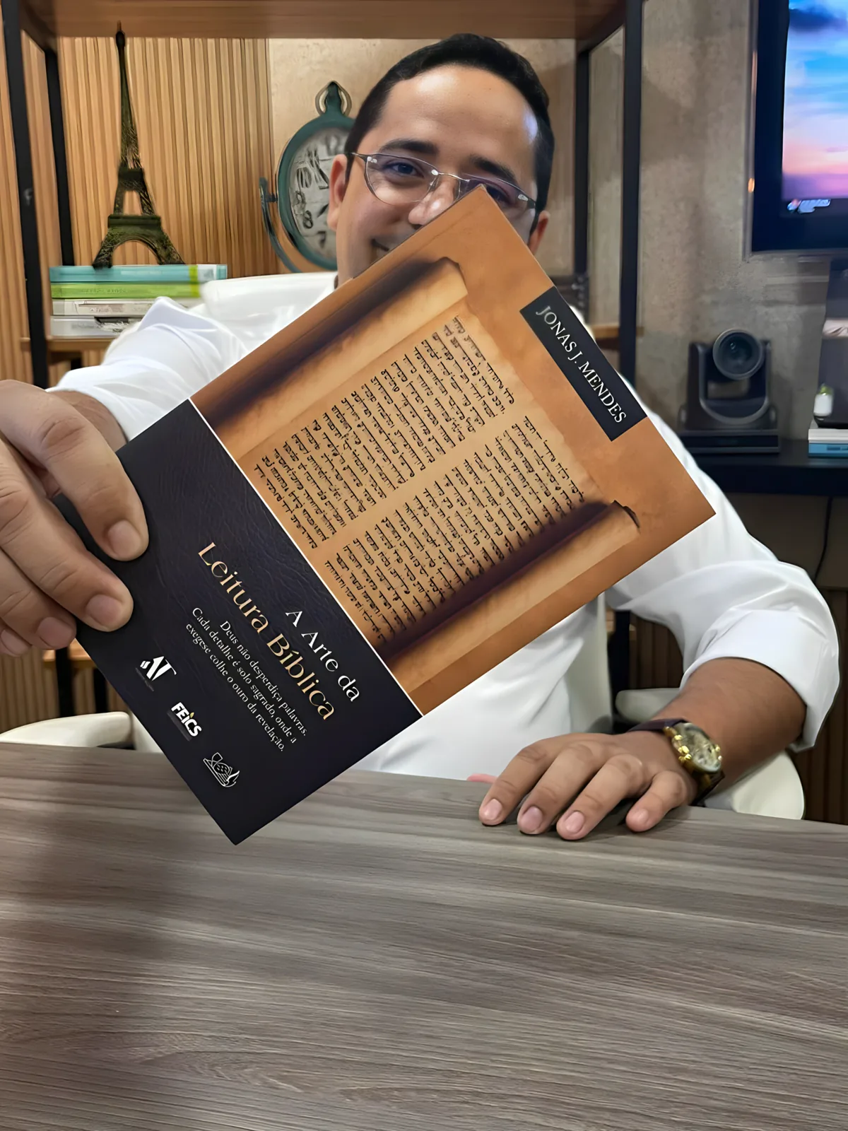 Pr. Jonas J. Mendes segurando o livro A Arte da Leitura Bíblica